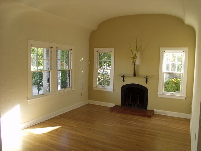Bright living room with stunning double-coved barrel ceiling and wood-burning fireplace.   Original wood floors throughout home.